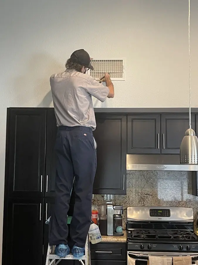 Technician inspecting an air vent during HVAC service in Waterville